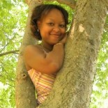 Photo of Patrice, smiling in a tree