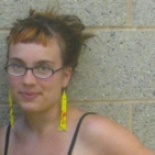 Stephanie Dank, with glasses and long yellow earrings