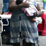 Iresha wearing a dress, holding a baby